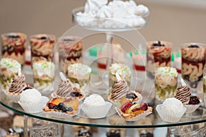 Candybar in a restaurant. Decorated white table fool of sweet pastry