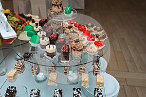Candybar in a restaurant. Decorated white table fool of sweet pastry