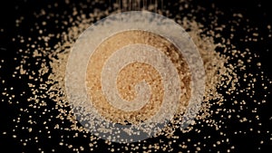 Cane sugar poured on a table on a black background.