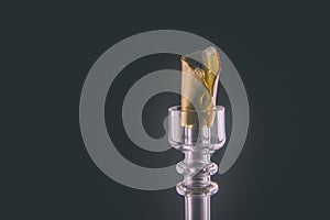 Cannabis resin aka shatter on glass rig isolated over black