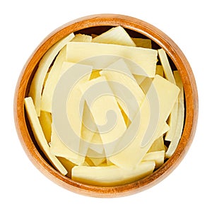 Canned bamboo shoots in wooden bowl over white