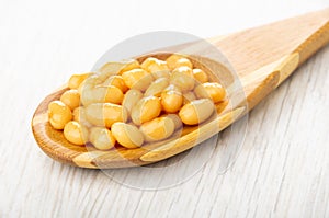 Canned bean in spoon on wooden table
