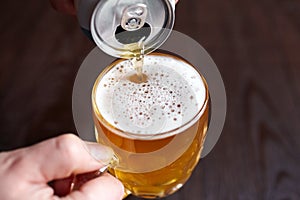 Canned beer puring into mug, light wheat beer