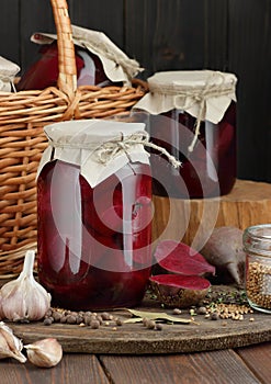 Canned beetroot in glass jars on rustic wooden background, closeup, food storage solution