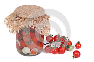 Canned cherry tomatoes in a glass jar and fresh tomatoes