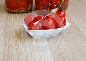 Canned cherry tomatoes in a small plate with a decorative fork