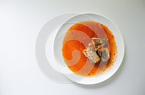 Canned fish in tomato sauce on white background