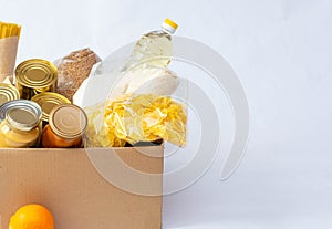 Canned food, pasta and cereals cardboard box. Food donations or food delivery concept.