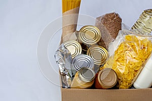 Canned food, pasta and cereals cardboard box. Food donations or food delivery concept.
