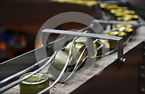 Canned food products on conveyor belt in distribution warehouse.