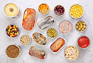 Canned food on stone background, top view