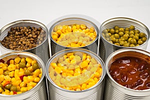 Canned food on white background. Green pea, beans, corn, lentils