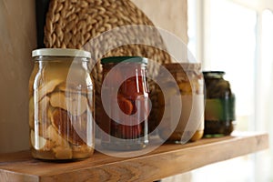 Canned foods on wooden shelf in kitchen