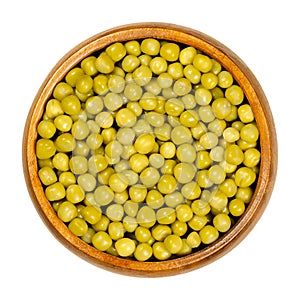 Canned green peas, seeds of Pisum sativum in wooden bowl