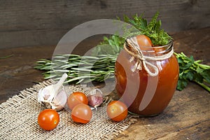 Canned marinated tomatoes in tomato juice on a wooden table