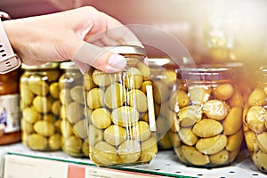 Canned olives in hands buyer in shop