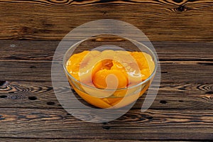 Canned peaches in a glass bowl on the table