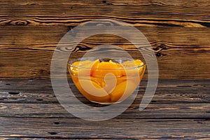 Canned peaches in a glass bowl on the table