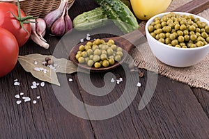 Canned peas and vegetables on an old wooden table.