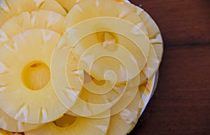 Canned pineapple on a plate on wooden table