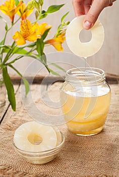 Canned pineapple rings with juice in hand