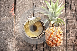 Canned pineapple on wood background