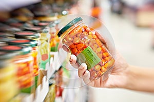 Canned red peppers in hand