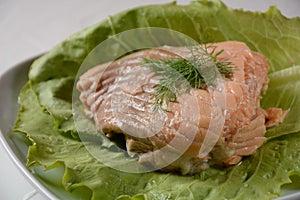 Canned salmon chunks with lettuce leaves,