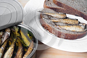 Canned sprats on rye bread served with herb baked potatoes