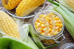 Canned sweet corn in glass jar, fresh and cooked corn on cobs.