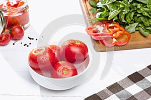 Canned tomatoes and fresh tomato on white background