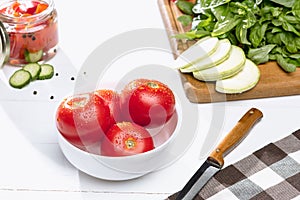 Canned tomatoes and fresh tomato on white background