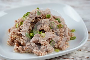 Canned tuna chunks decorated with sliced green onion