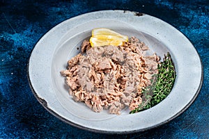 Canned Tuna chunks in olive oil ready for eat. Blue background. Top view