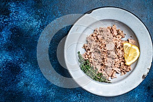 Canned Tuna chunks in olive oil ready for eat. Blue background. Top view. Copy space