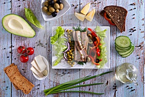 Canned tuna slices with fresh vegetables healthy food on wooden background flat lay