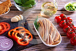 Canned tuna slices with fresh vegetables healthy food on wooden background flat lay