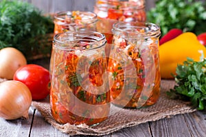 Canned vegetable salad in glass jars and ingredients for homemade