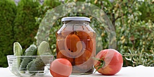 Canned vegetables in glass jars. Pickled cucumbers and tomatoes