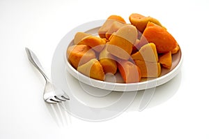 Canned yams on a white reflective table photo