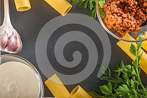 Cannelloni on a plate with meat and tomato sauce. Italian paste. Crude cannelloni on a kitchen table. Top view. Canneloni Pasta w photo