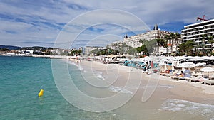 Cannes, Cote d`Azur, France - October 2019: People sunbathing on a hot summer day on the beach along the Promenade de la Croisett