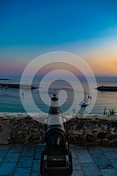 Cannon aiming at the beach at sunset