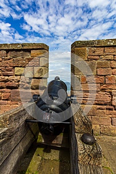 Cannon pointing through rampart toward the sea