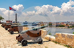 Cannons at Fort of Saint Charles, cuban flag and cruise ship in Havana