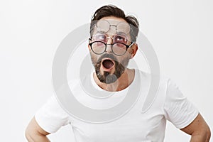 Cannot pick pair of glasses, all awesome. Portrait of funny adult playful man with beard and moustache putting on three