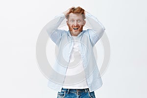 Cannot stop panicking. Portrait of anxious emotive european redhead man with bristle pulling hair out of head, gasping