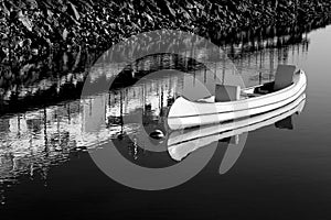 Canoe anchored on calm water in Tavira