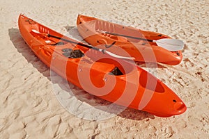 canoe and kayak with paddles lie on a sandy beach on a tropical island, waiting for adventurers and tourists to explore the