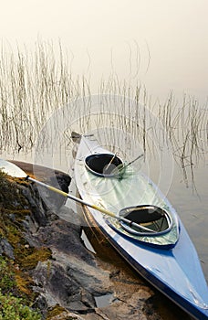 Canoe with oar and fishing-tackle in Wilderness